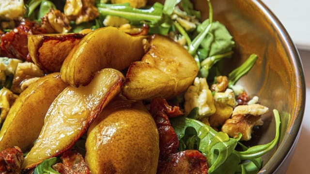 Ensalada de pera rostizada con queso azul, tomate seco, nueces y rúcula