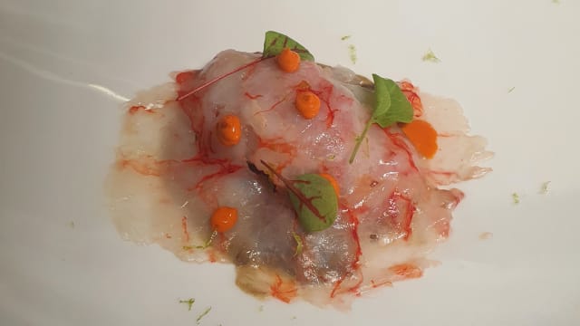 Tartare di Wagyu ricoperta da petali di gambero rosso e il suo corallo, su zuppetta di lenticchie igp