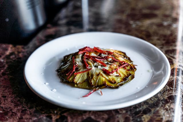 Alcachofa confitada con jamón y su jugo