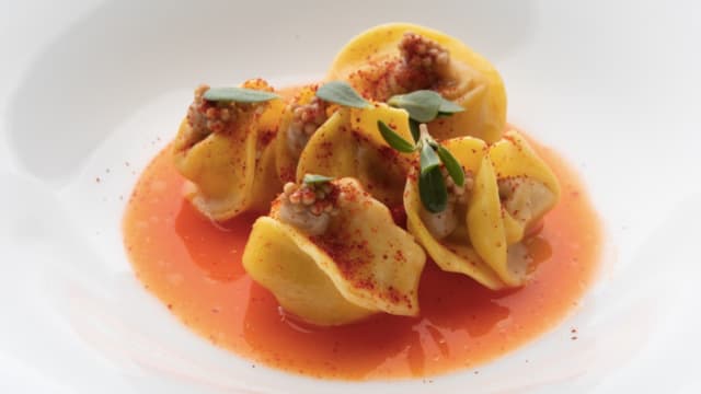 Tortelli di erbe spontanee, aglio nero e albicocca Pasta ripiena di patate ed erbe, crema d’aglio nero, pesto di pomodoro secco, albicocca in conserva, latte alla ricotta mustia.