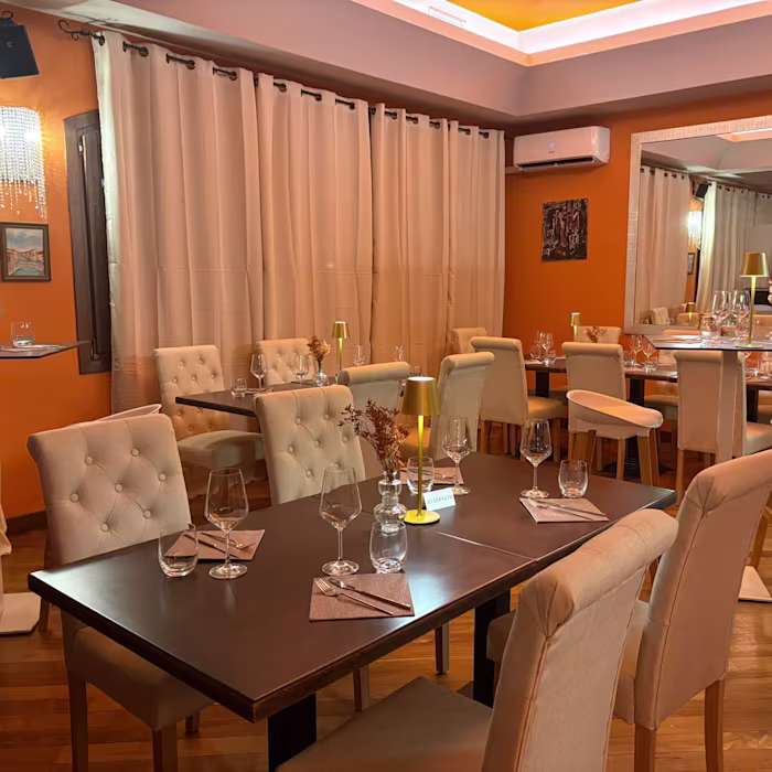 Sala con tavoli apparecchiati e tende chiare