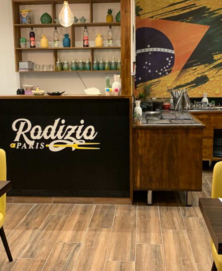 Comptoir en bois du restaurant Rodizio Paris avec fresque murale inspirée du Brésil